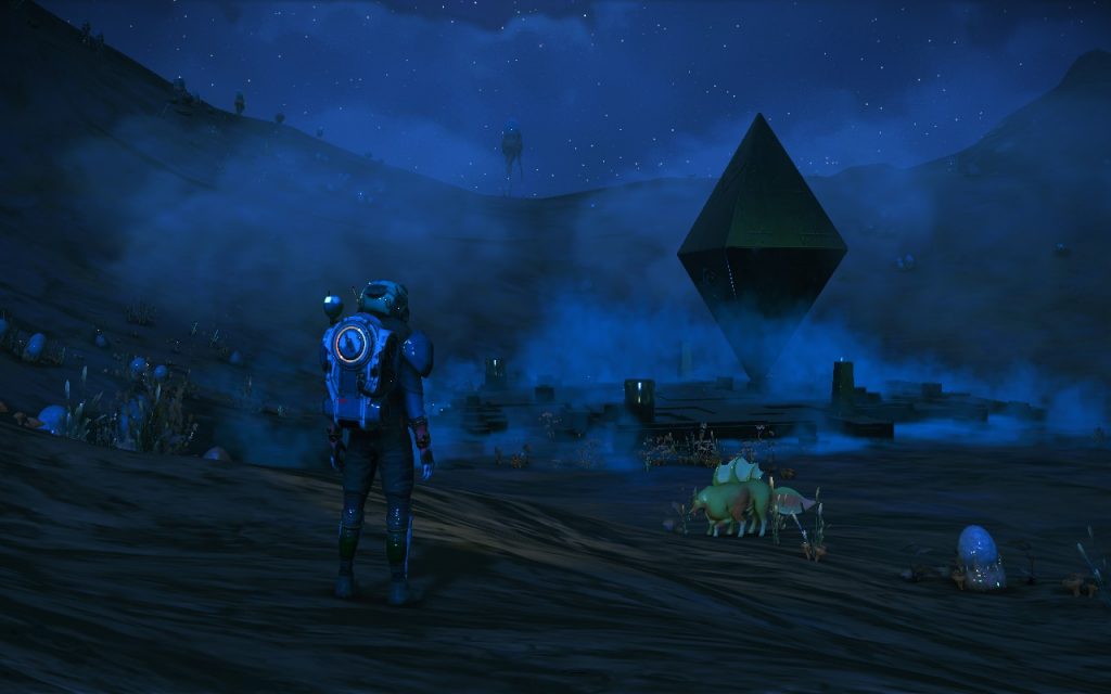 Screenshot from "No Man's Sky", showing an astronaut figure in a dark landscape, staring towards a mysterious large diamond-shaped object.