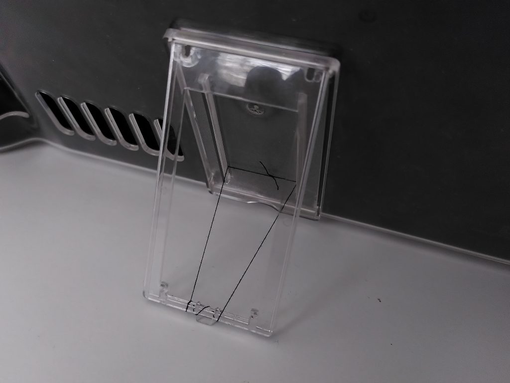 Photo showing the back of the protective case, kickstand out, being held in place by a loop of thin, black thread.