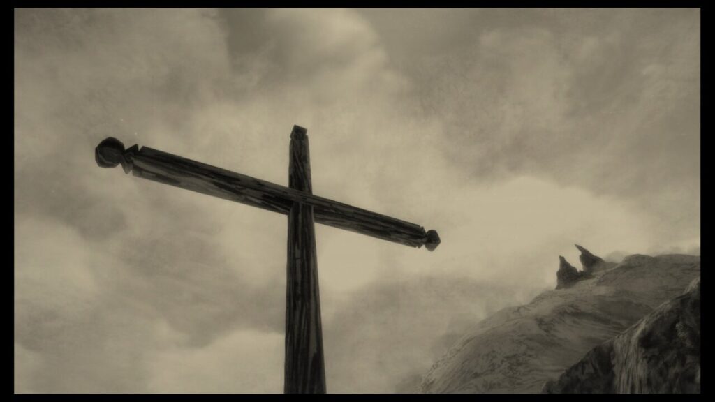 Screenshot from "Mundaun", showing a wooden cross in the foreground, and two craggy, sharp peaks rising into the air in the background,